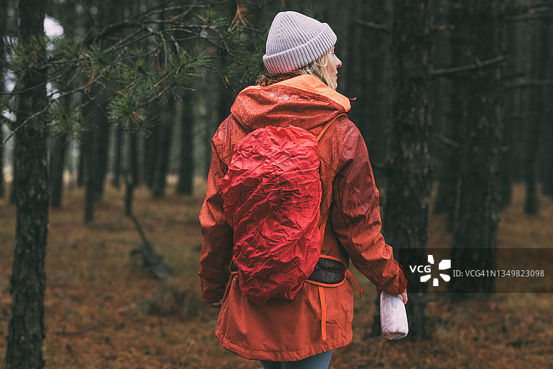 携带真空瓶在树林中漫步的徒步旅行者图片素材