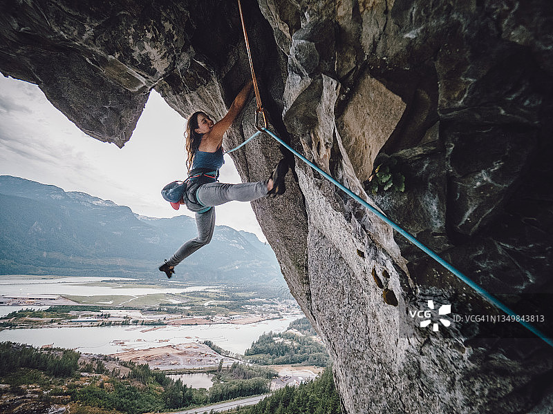 女性攀岩者在500米高的岩壁上攀爬图片素材