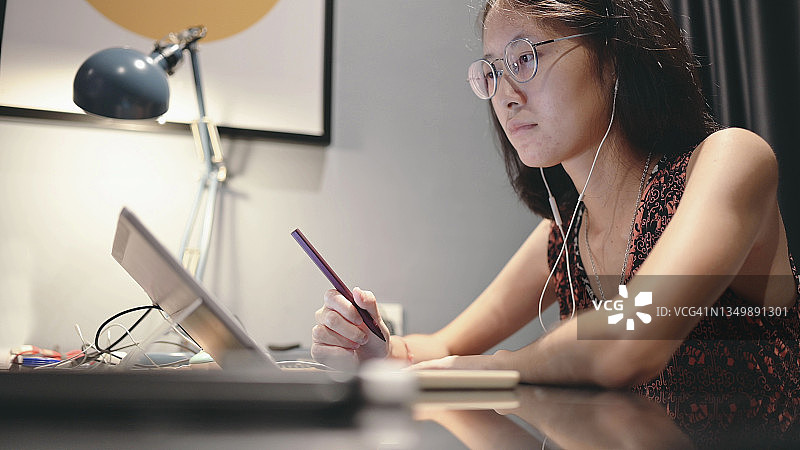 一位东南亚女性在笔记本电脑前感到无聊，在线学习遇到问题图片素材