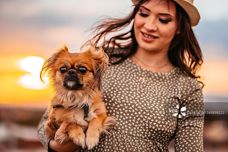 手抱京巴犬的漂亮女人图片素材