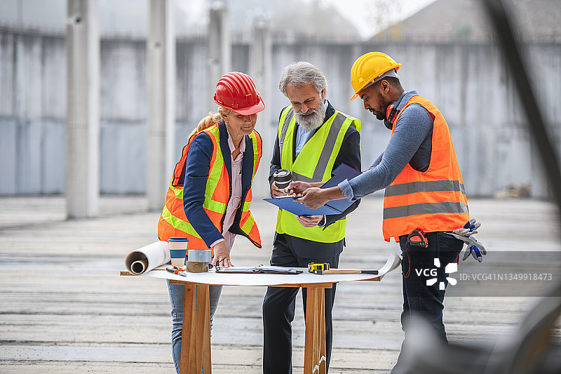 开发人员和工头在施工现场查看计划图片素材
