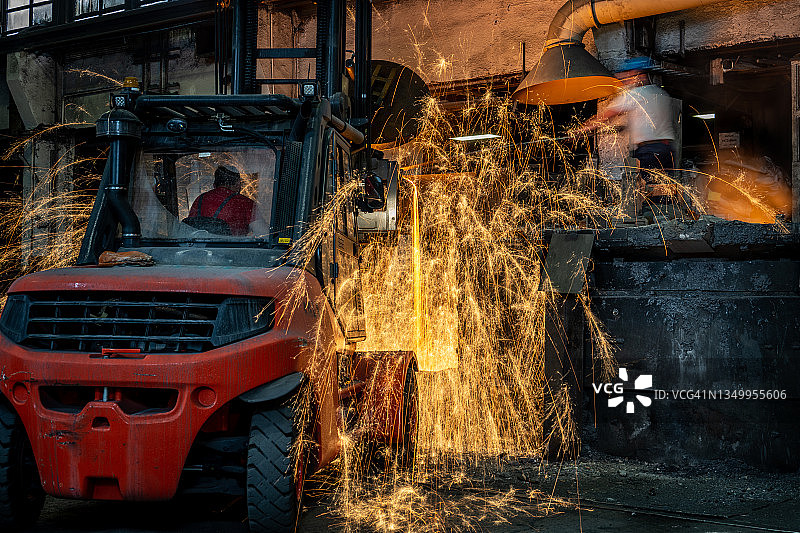 用叉车将液态熔融金属倒入铸造模具中图片素材