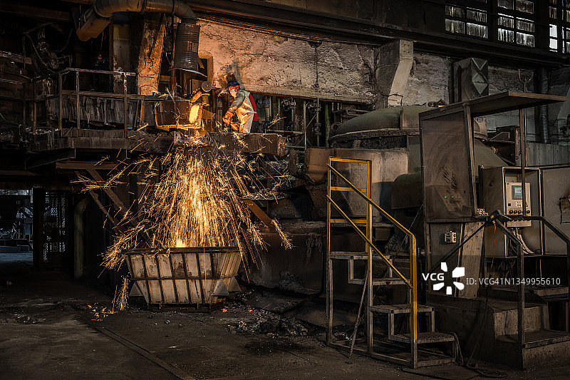铸造工人向容器中倾倒熔融金属图片素材