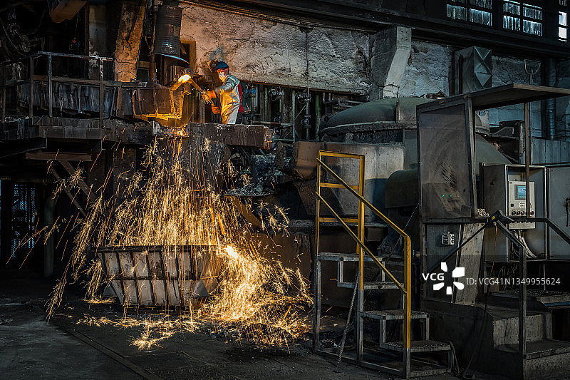 铸造工人向容器中倾倒熔融金属图片素材