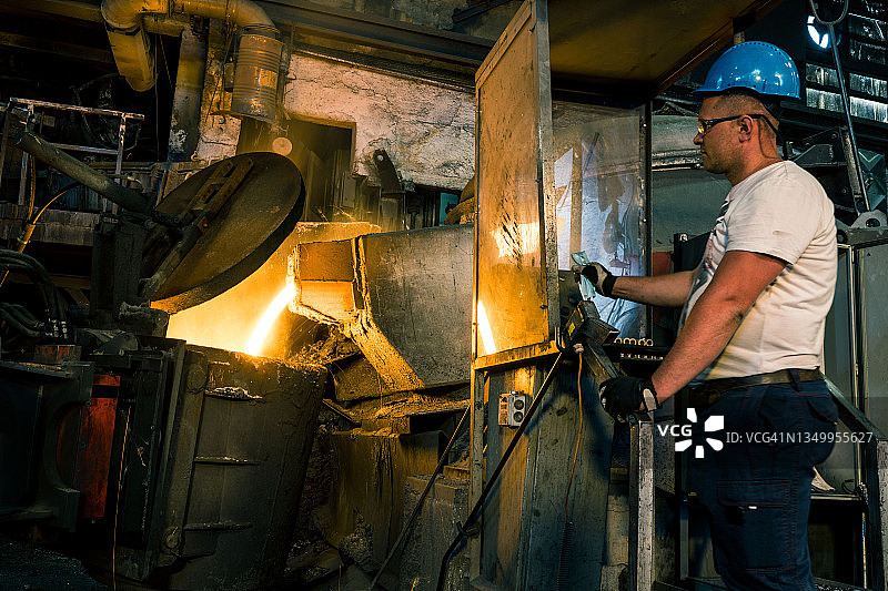 将加热炉中的热金属液体倒入钢厂的容器中图片素材