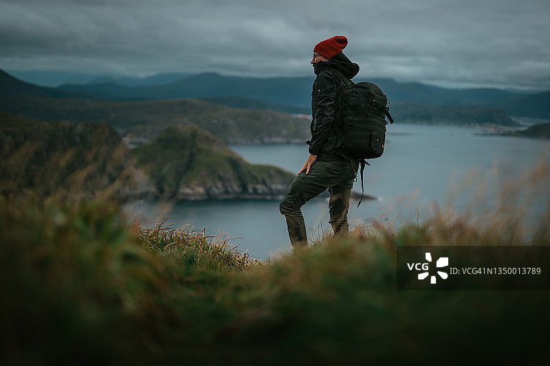 荒野中的现代小屋：宽大的全景窗与男人轮廓图片素材