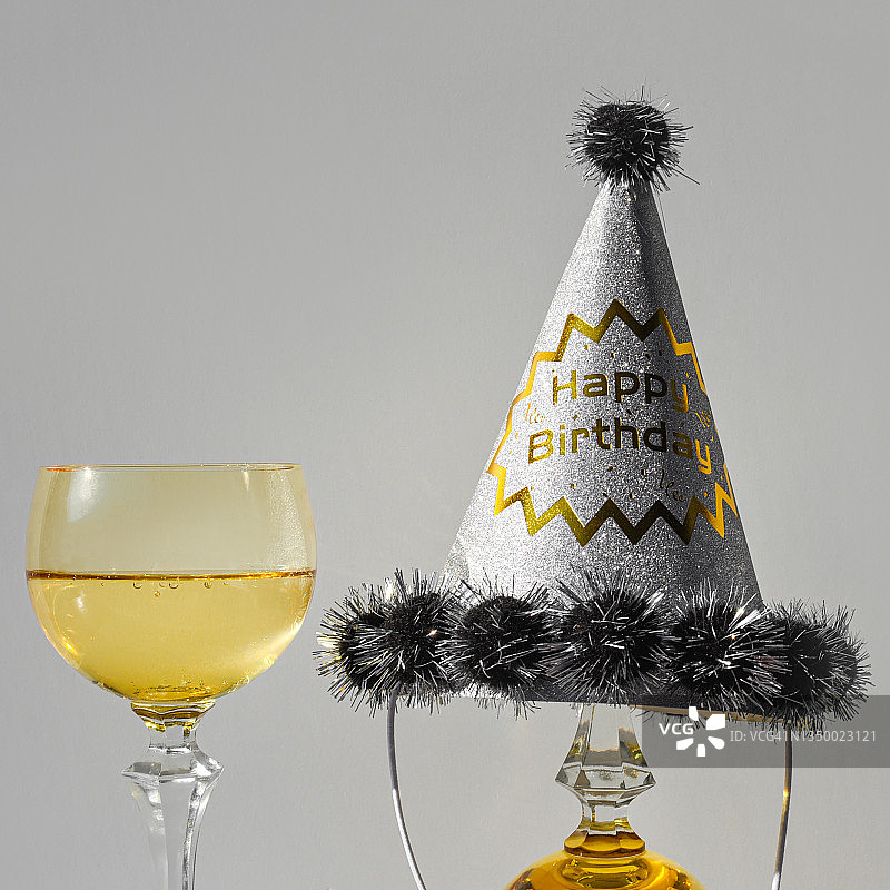 一杯戴着生日帽的香槟图片素材