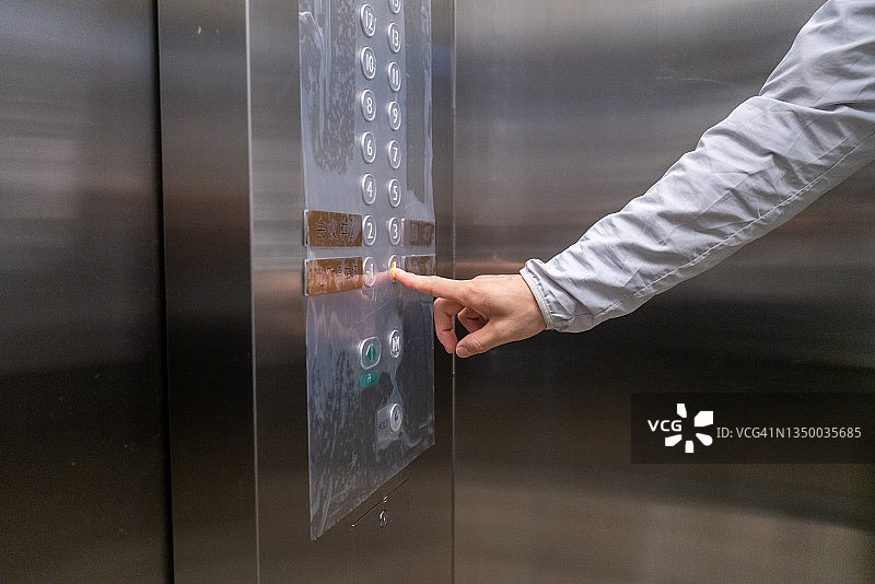 一只手按下电梯里的一楼按钮图片素材