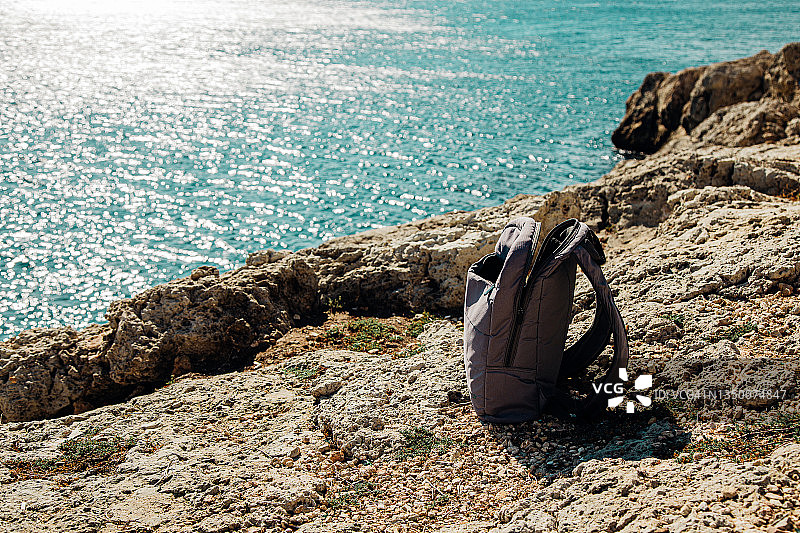 旅行背包在海边岩石上图片素材