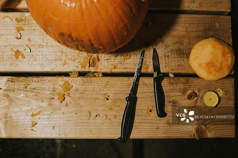 木桌上完整的成熟橙色南瓜和刀具图片素材