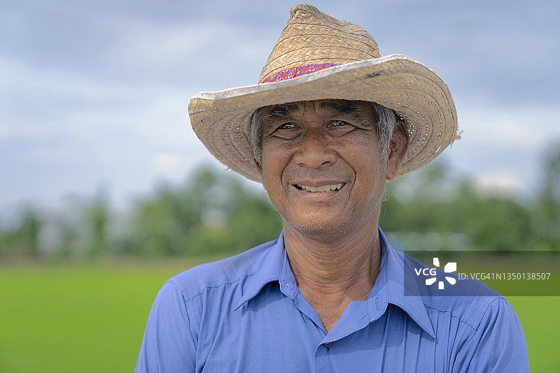 在稻田里幸福微笑的泰国农民图片素材