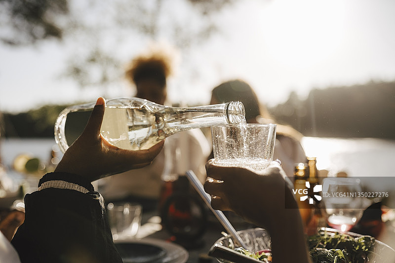女子在晚宴上为朋友倒葡萄酒图片素材