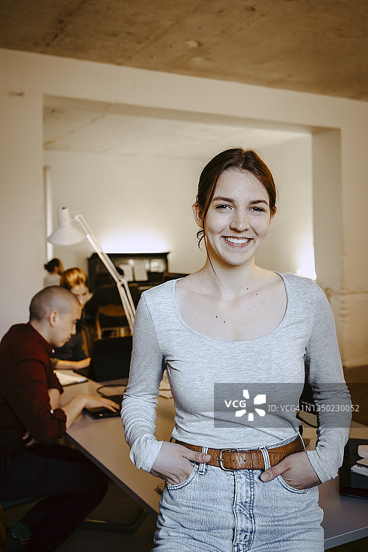 微笑女商人画像，同事在办公室办公桌前工作图片素材