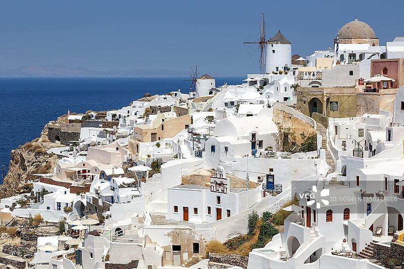 在希腊圣托里尼地中海上，圣托里尼岛的伊亚小镇假日旅行，有风车图片素材