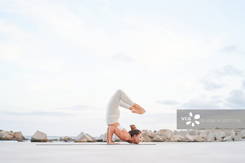 抬起双腿，双脚靠近头部的柔韧女子侧视图图片素材