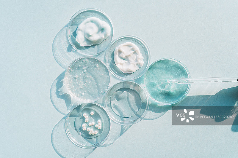 玻璃滴管与培养皿中的面霜精华液，化妆品实验室研究概念，扁平风格图片素材