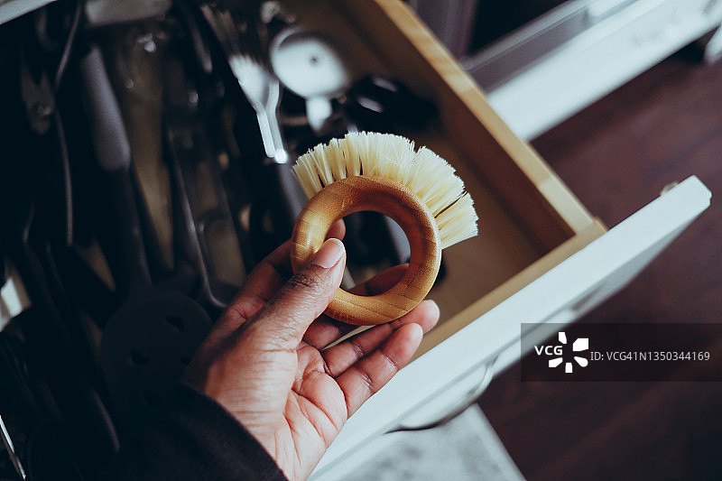 女士从厨房抽屉里拿出蔬菜刷图片素材