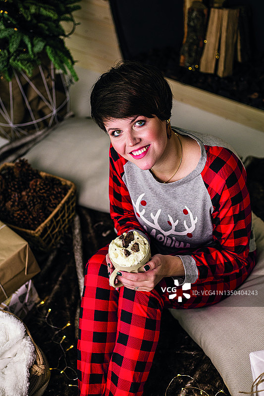 圣诞节期间手持咖啡杯的睡衣美女图片素材