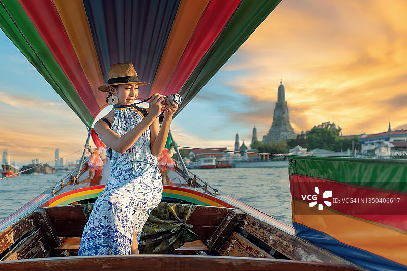 女游客乘坐长尾船在泰国阿伦寺放松身心。旅行概念。图片素材