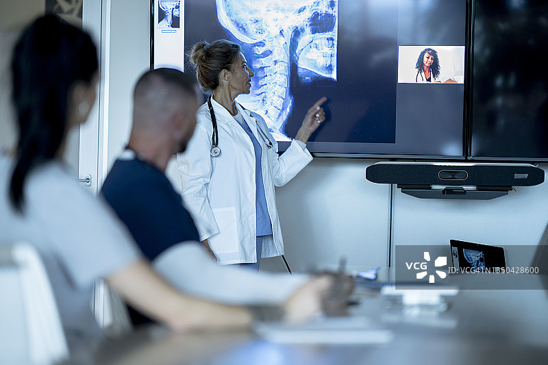 医疗专业人员开会讨论病人扫描结果图片素材