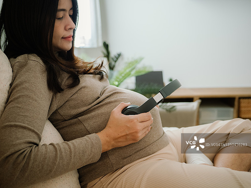 亚洲孕妇坐在卧室里图片素材