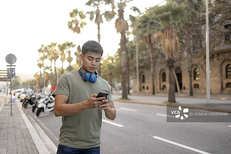 用智能手机呼叫网约车的混血年轻男人图片素材