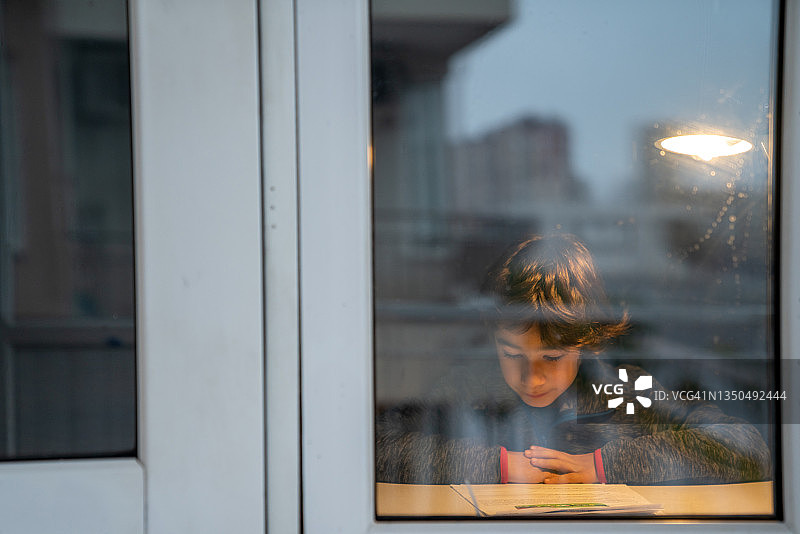小学生在家中黑暗处学习图片素材