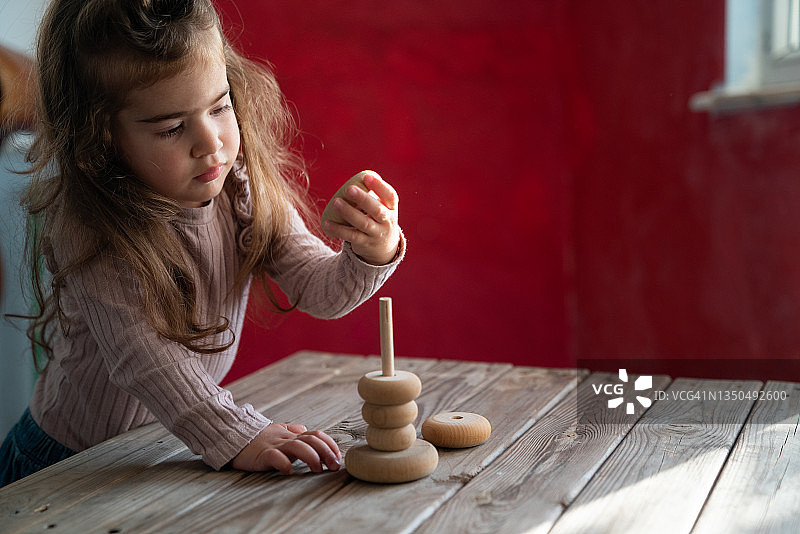 学龄前女孩玩木制零件的照片图片素材