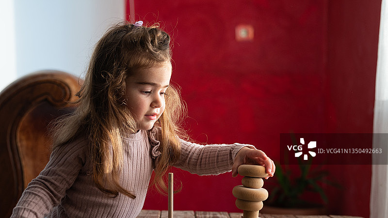 学龄前女孩玩木制零件的照片图片素材