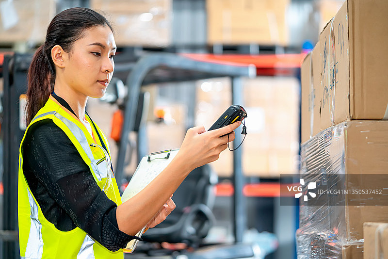 仓库工人用扫描仪核对货物，并将数据与剪贴板进行比较图片素材