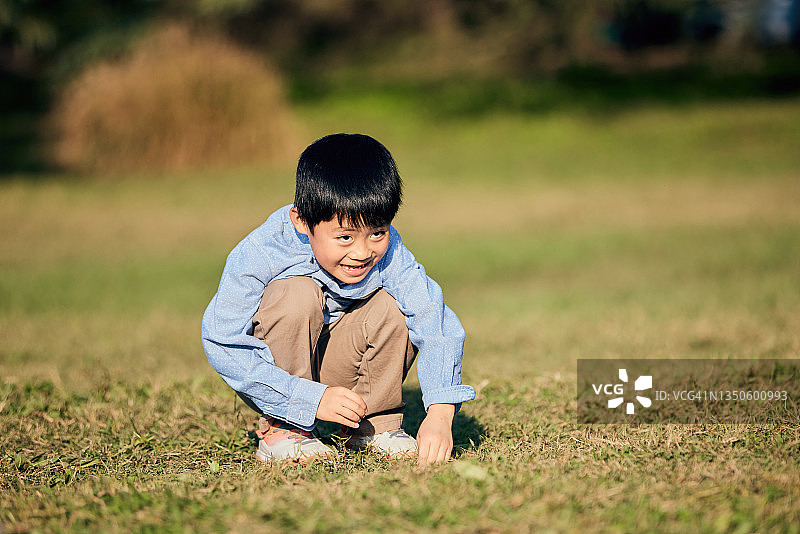 在草地上玩耍的亚洲男孩图片素材