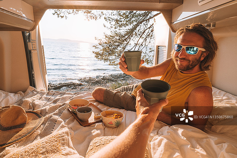 情侣在露营车中享用日落饮品图片素材