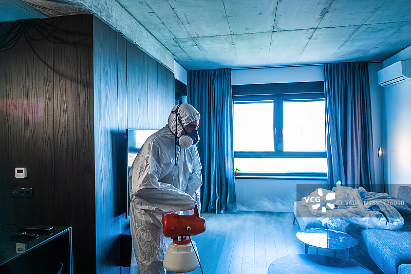 防护服人员正在屋内喷洒消毒剂图片素材