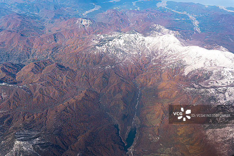 从飞机上俯瞰日本新泻的雪山和秋色图片素材