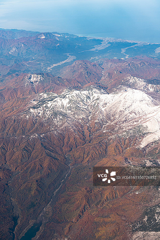从飞机上俯瞰日本新泻的雪山和秋色图片素材