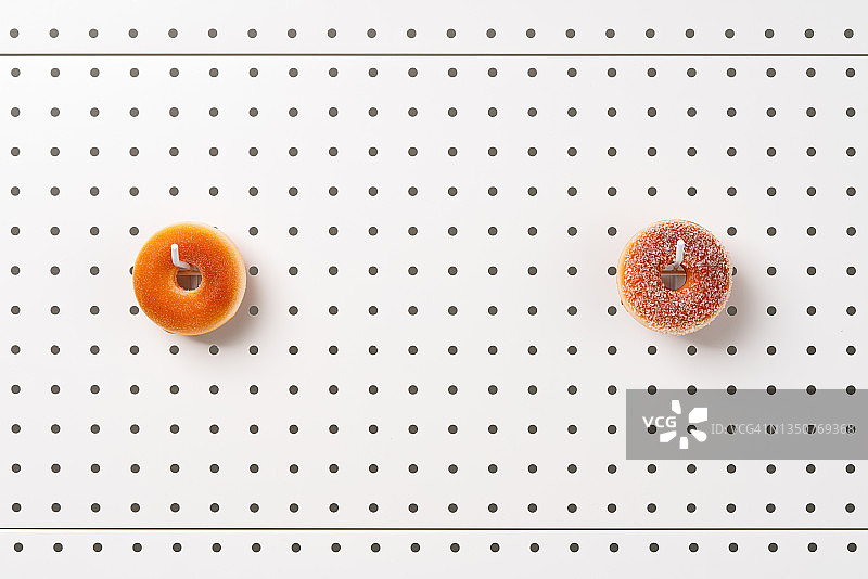 挂在白色钉板上的甜甜圈图片素材