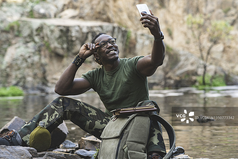 在山里用背包自拍的年轻旅行者图片素材