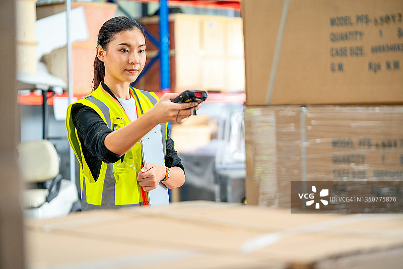 仓库管理员使用扫描仪检查仓库中的货物数量，并准备数据发送给仓库管理系统图片素材
