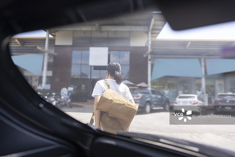 在超市购物前，打开后车门并戴着防护口罩的亚洲青年女性图片素材