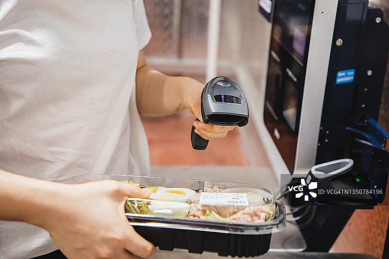 亚洲女性在超市自助结账机结账图片素材