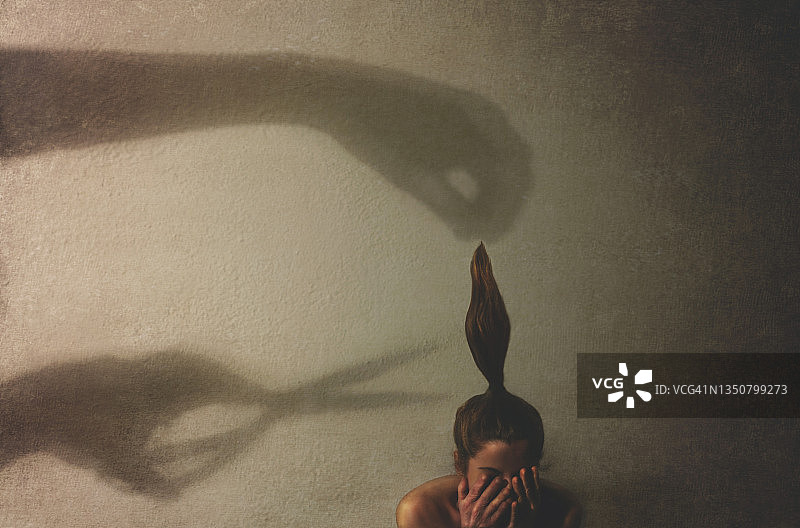 女子被巨手的影子吓到图片素材