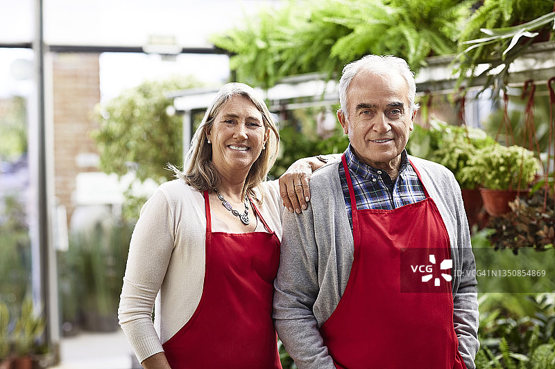 自信的年长花艺师在温室里图片素材
