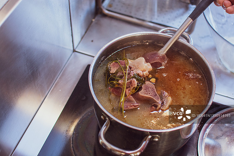 在大锅中烹饪剩余的骨汤图片素材