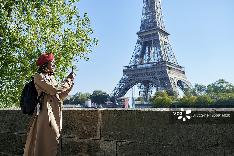 女人在埃菲尔铁塔用手机拍照图片素材