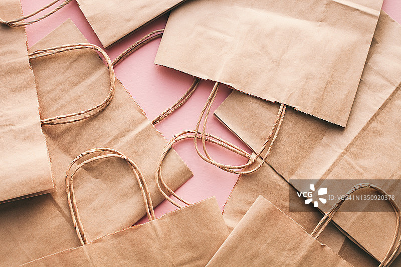 粉色背景上的纸质购物袋：促销和黑色星期五的概念图片素材