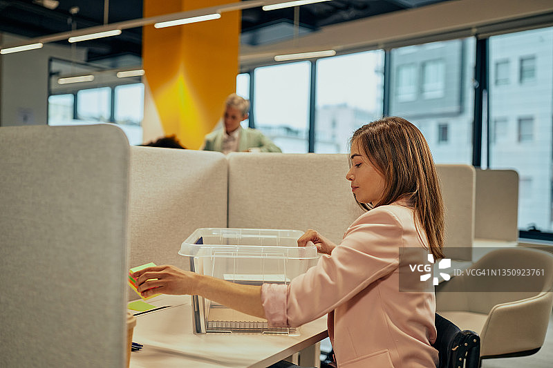 女商人打开办公桌上的办公用品图片素材