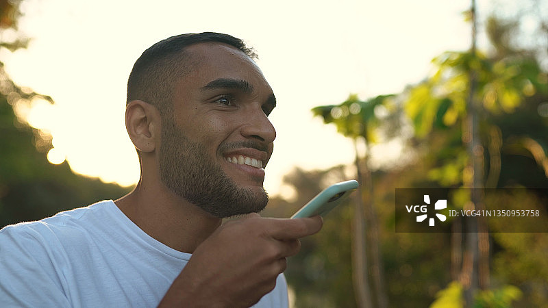 男子在日落时分的森林里使用智能手机图片素材