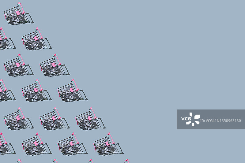 灰色背景上的金属粉色购物车图案，具有阴影，左侧留有复制空间。购物、折扣和黑色星期五概念图片素材