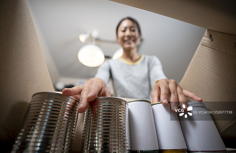 志愿者在食物银行用罐头食品包装捐赠箱图片素材