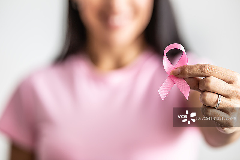 女性手持粉色丝带提高乳腺癌意识的细节图片素材